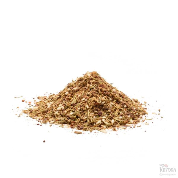 Za’atar-krydderblanding med sumak, timian, svart spisskummen, koriander, sesamfrø, Aleppo chili og gresk oregano, presentert på en hvit bakgrunn.