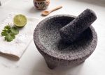 Molcajete i lavastein med tejolote på hvit marmorbenk