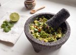 Ferdig guacamole servert i molcajete med lime og koriander