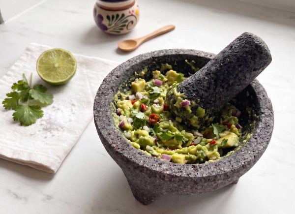 Ferdig guacamole servert i molcajete med lime og koriander