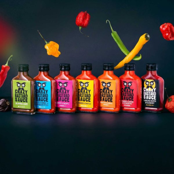Syv Crazy Bastard hot sauces fra Klassikerboksen oppstilt på rekke