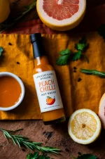 Løkken peach chilli hot sauce med en skål som viser en ferskenfarget saus