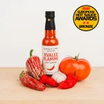 Løkken - Hvaler Flamme Hot Sauce i tomatfarget liten flaske med grønnsaker og chili og hvitløk