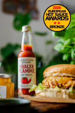 Løkken Hvaler Flamme hot saus stående ved siden av en lekker hamburger