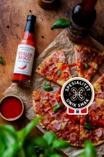 Løkken hvaler basco hot sauce ved en lekker tynnbunnet pizza med spekeskinke