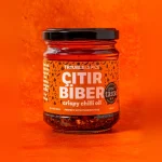 Glass med oransje etikett og innhold